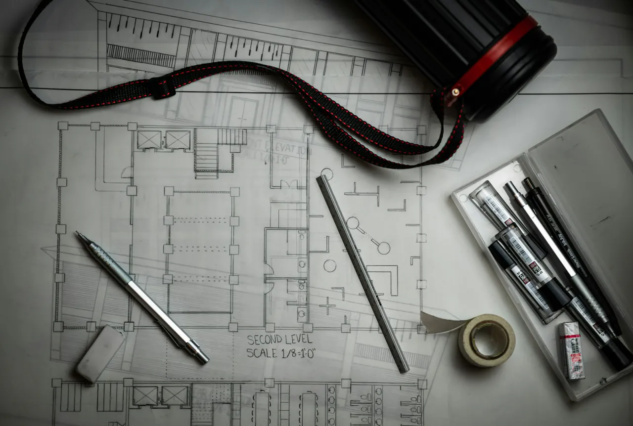 Floor plans, drafting tools and a drawing tube