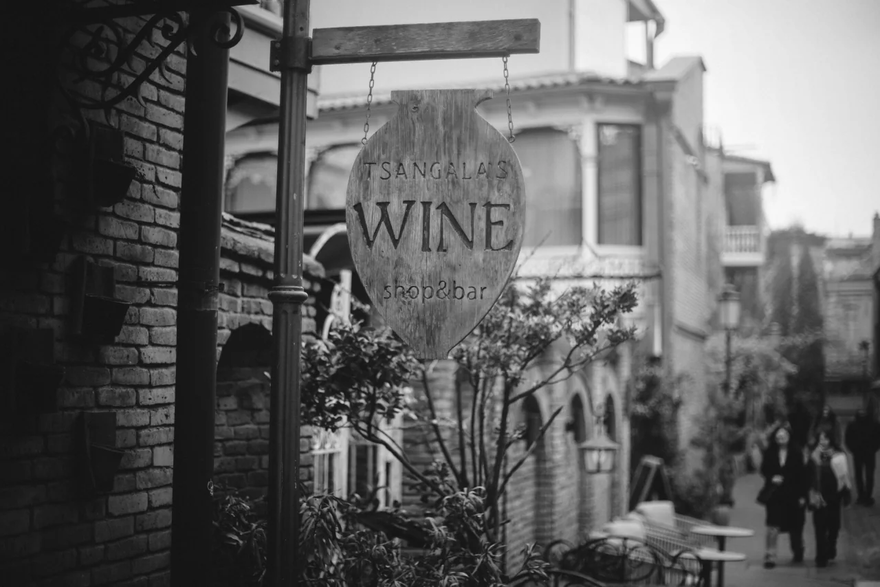 A wine bar sign hanging over a street in the old town of Tbilisi